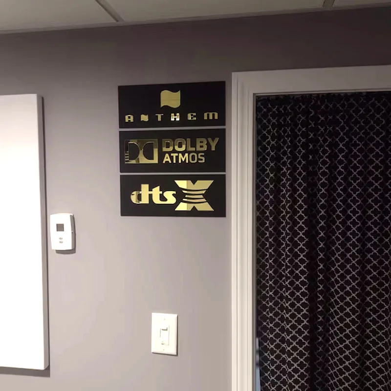 Mehrere Heimkino 3D Wandschilder an der Wand montiert — Anthem, Dolby Atmos, DTS:X